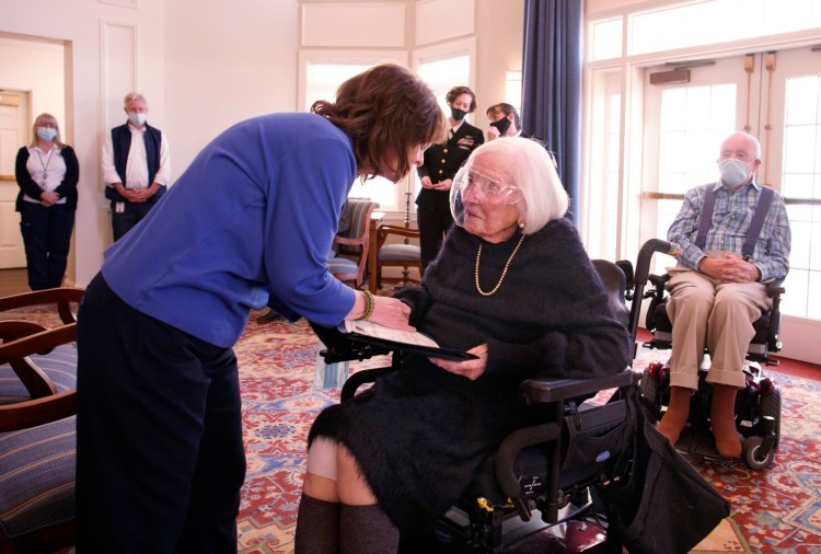 Joy Asuncion, a retired Navy chief petty officer, hands a certificate of appreciation to Jane Case, who served as a Code Girl in the Navy WAVES during World War II. Case was honored for her service on Tuesday, the 80th anniversary of the Pearl Harbor attack, at Piper Shores in Scarborough.