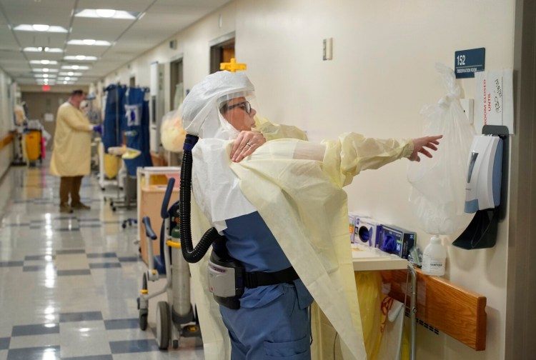 Taylor Bourque, an RN at Stephens Memorial Hospital in Norway, dons PPE while working in the negative pressure COVID-19 wing. 