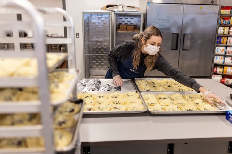 Preble Street volunteer Sage Collins wraps up bean and cheese tacos Monday at Preble Street’s new Food Security Hub. The hub, housed in a 30,000-square-foot space in South Portland, is designed to foster a sustainable, comprehensive and collaborative approach to ending hunger in the state.