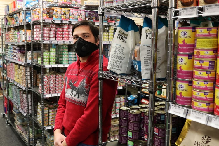 Will Paul, co-owner of The Animal House in Westbrook and Damariscotta, stands among shelves of canned cat food at the Westbrook store. He said customers have come in looking for cat food, asking for something similar to Friskies or another brand, because they can't find their cat's usual dinner.