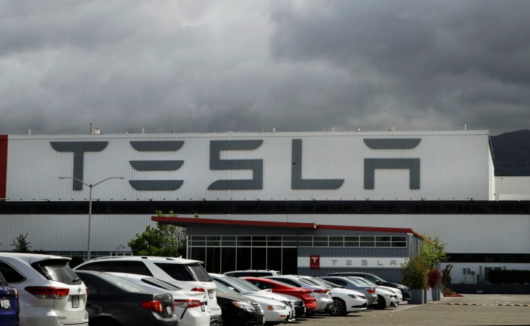 FILE - This May 12, 2020, file photo shows the Tesla plant, in Fremont, Calif. A jury in San Francisco says Tesla must pay nearly $137 million to a Black former worker who said he suffered racial abuse at the electric carmaker's San Francisco Bay Area factory. The jury in San Francisco agreed Monday, Oct. 4, 2021, that Owen Diaz was subjected to racial harassment and a hostile work environment. (AP Photo/Ben Margot, File)