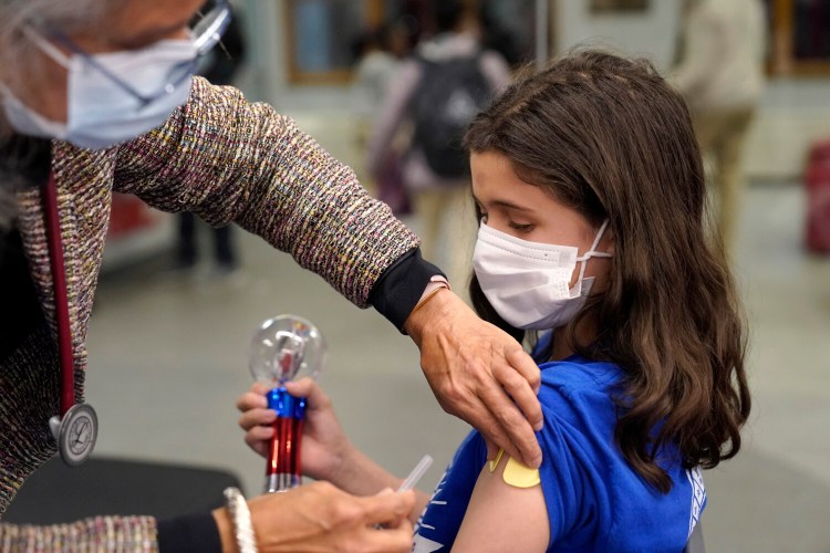 Jehna Kottori, 10, of Worcester, Mass., gets a shot of Pfizer COVID-19 vaccine on Thursday at a mobile vaccination clinic in Worcester. Children between the ages of 5 and 11 became eligible for a dose of the Pfizer-BioNTech vaccine on Nov. 2.