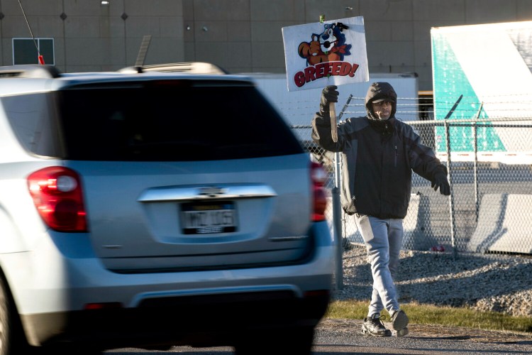 Rodney Conyers Sr. holds a sign outside the Kellogg's plant on I Street in Omaha, Neb. on Tuesday, Dec. 7, 2021. Kellogg’s workers have overwhelmingly rejected a new contract that would have given them 3% raises, so the strike that began Oct. 5 will continue at the company’s four U.S. cereal plants.   (Lily Smith/Omaha World-Herald via AP)
