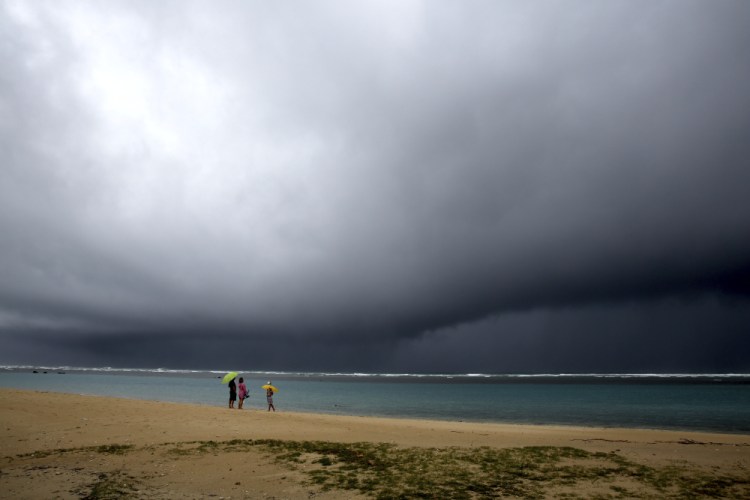 Rain begins to fall on a beach in Honolulu on Monday.

