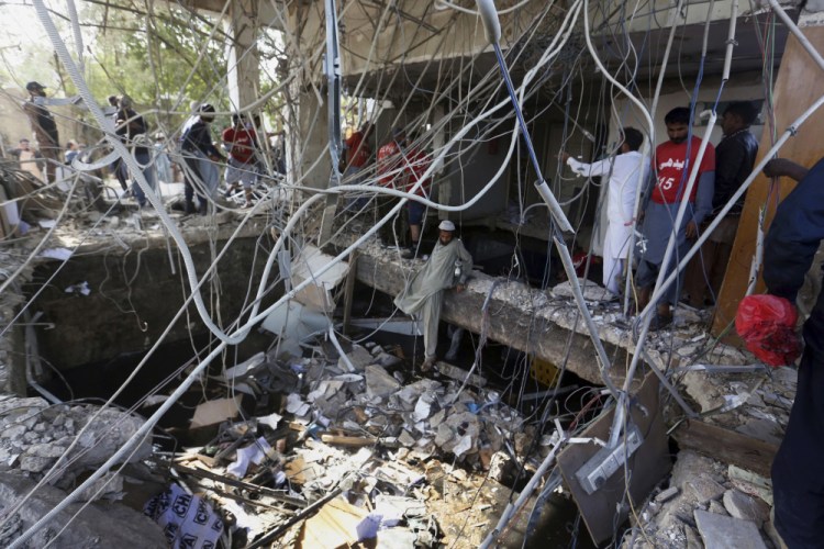 Rescuers inspect the scene of a gas explosion in Karachi, Pakistan, on Saturday.

