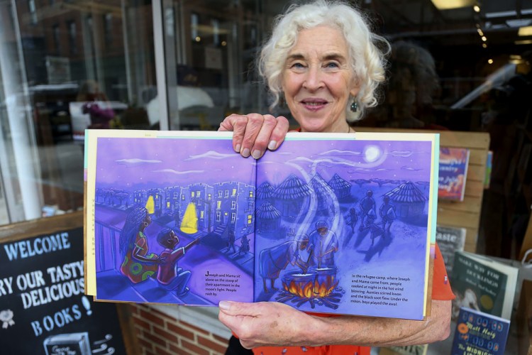Terry Farish, who published a children's book that she co-authored with a refugee from Africa, is seen at River Run Bookstore in Portsmouth, N.H. 