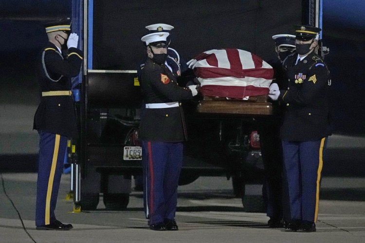 A joint services military bearer team moves the casket of former Sen. Bob Dole, R-Kan., after arriving at the airport in Salina, Kan., on Friday.

