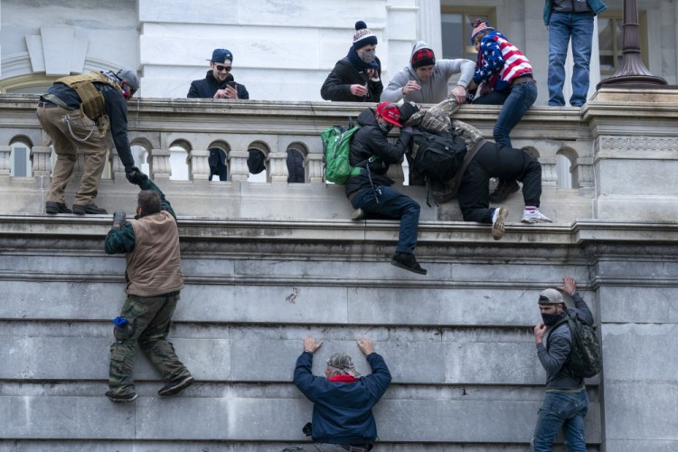 Insurrectionists loyal to President Trump climb the west wall of the Capitol on Jan. 6 in Washington.

