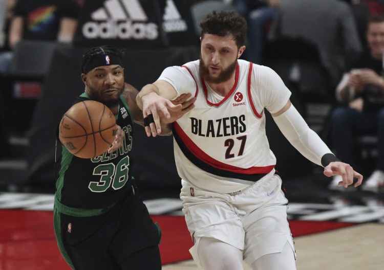 Celtics guard Marcus Smart, left, and Portland Trail Blazers center Jusuf Nurkic, right, battle for a loose ball during the first half of Saturday.