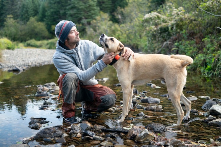 Dub Paetz and his dog Hank, a 3-year-old boxer mix, pose in the woods. They're among the human-dog teams featured in new National Geographic survival show "Called to the Wild."