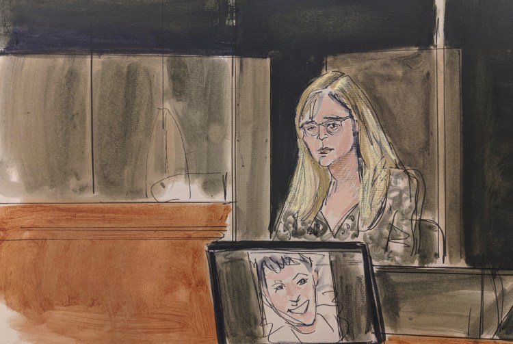 In this courtroom sketch, Annie Farmer testifies on the witness stand during the Ghislaine Maxwell sex abuse trial, Friday in New York. A photo of Maxwell appears on a screen at foreground.