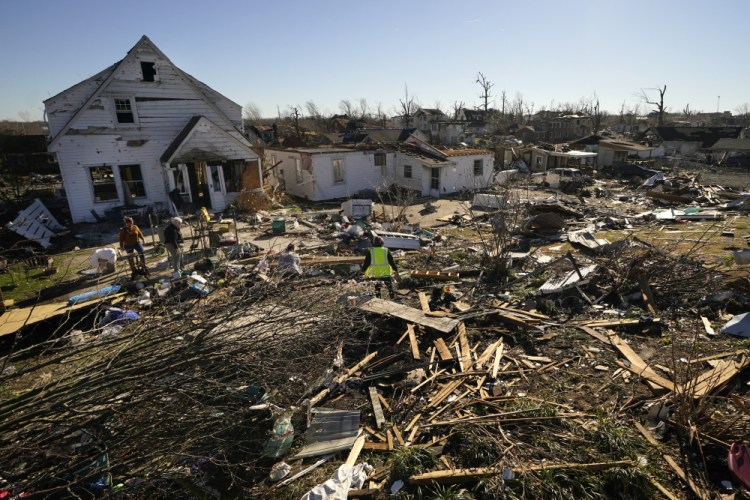 Volunteers help Martha Thomas, second from left, salvage possessions from her destroyed home in the aftermath of tornadoes that tore through the region, in Mayfield, Ky., on Monday. 