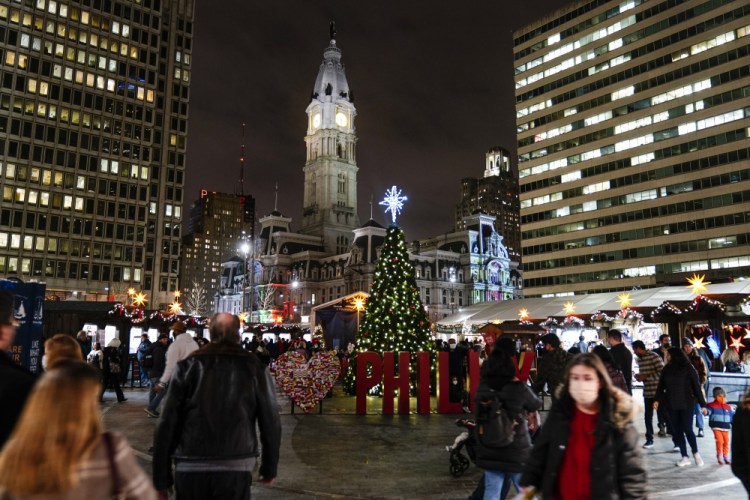 People visit the Christmas Village in Philadelphia on Wednesday. 
The explosive spread of the omicron variant is causing many to wonder if they should cancel their holiday plans. 

