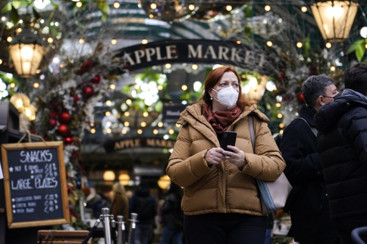 A woman walks in Covent Garden market, in London on Thursday. The U.K. recorded the highest number of confirmed new COVID-19 infections Wednesday since the pandemic began, and England's chief medical officer warned the situation is likely to get worse as the omicron variant drives a new wave of illness during the Christmas holidays. 

