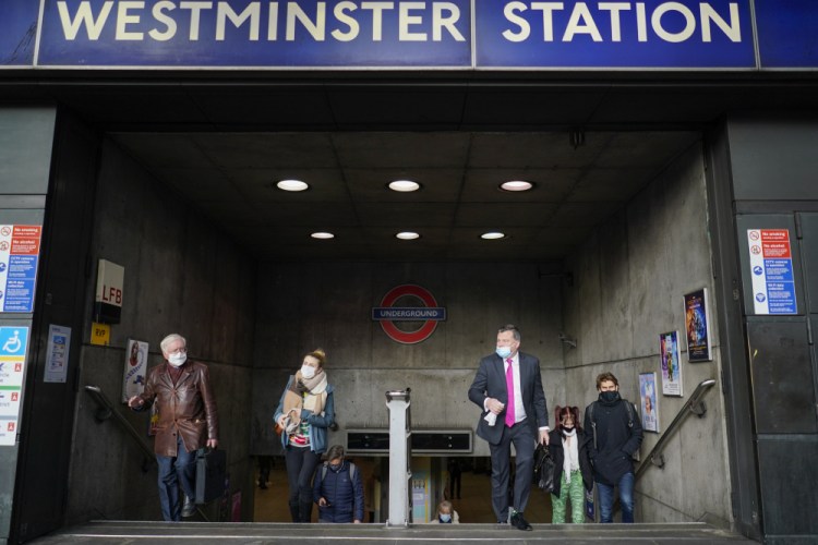 Passengers exit Westminster underground station in London on Thursday. Britain's Prime Minister Boris Johnson said, beginning Monday, people should work from home if possible. On Friday, the legal requirement to wear a face mask was widened to most indoor public places. Next week, having a COVID-19 pass showing a person has had both vaccine doses will be mandatory to enter nightclubs and places with large crowds.
