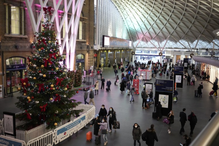 People walk past a Christmas tree Friday in King's Cross train station in London on Friday. After the U.K. recorded its highest number of confirmed new COVID-19 infections since the pandemic began, France announced Thursday that it would tighten entry rules for those coming from Britain.