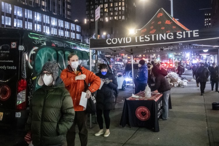 People wait on line to get tested for COVID-19 on the Lower East Side of Manhattan, Tuesday, Dec. 21, 2021, in New York.  