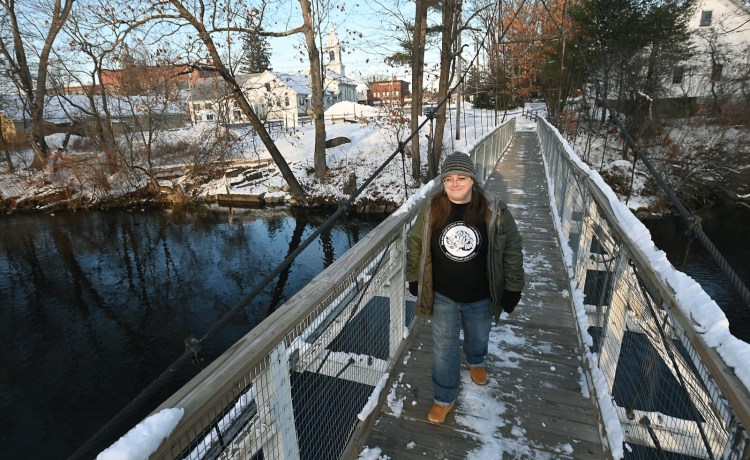 Sass Linneken crosses the swinging bridge in Skowhegan in December. The 43-year-old Skowhegan resident is part of a group quietly looking into whether Maine should begin providing direct cash payments to low-income residents to supplement other safety net programs. 