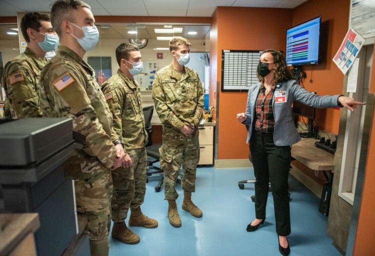 Jessica Dagneau, system manager of care management at Central Maine Medical Center, shows Maine National Guard members in December part of the Lewiston hospital's operations. The Guard is helping alleviate staffing shortages due to COVID-19.