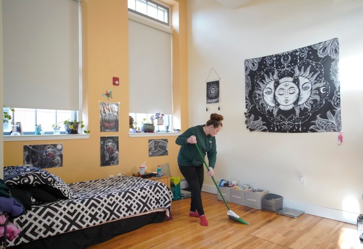 Tabitha Richards sweeps her room at Freedom Place, a new transitional housing program in Portland for women who were homeless or are recovering from substance use disorder. In addition to living at Freedom Place, Richards will work for Amistad as a peer support specialist for women in recovery. 