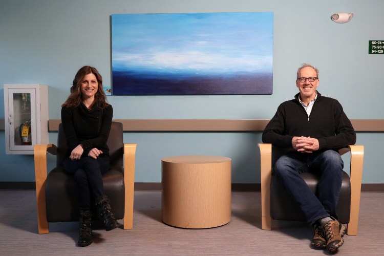 Marni Prince and Cullen Ryan sit below a painting by Sue Vittner in the common area of a building at the Northfield Green complex in the North Deering neighborhood of Portland. Prince is co-founder of Maine Art Collective, which has collaborated with Community Housing of Maine to install original Maine art in affordable housing complexes.