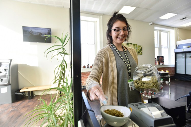 WasiinNaytha RaggedRobe weighs marijuana buds for a customer at Cannabis Corner in downtown Helena, Mont. Saturday Jan. 1, 2022. During the first weekend it was legal for adults 21 and over to purchase recreational marijuana in Montana, state license businesses sold more than $1.5 million in products the Department of Revenue said. (Thom Bridge/Independent Record via AP)