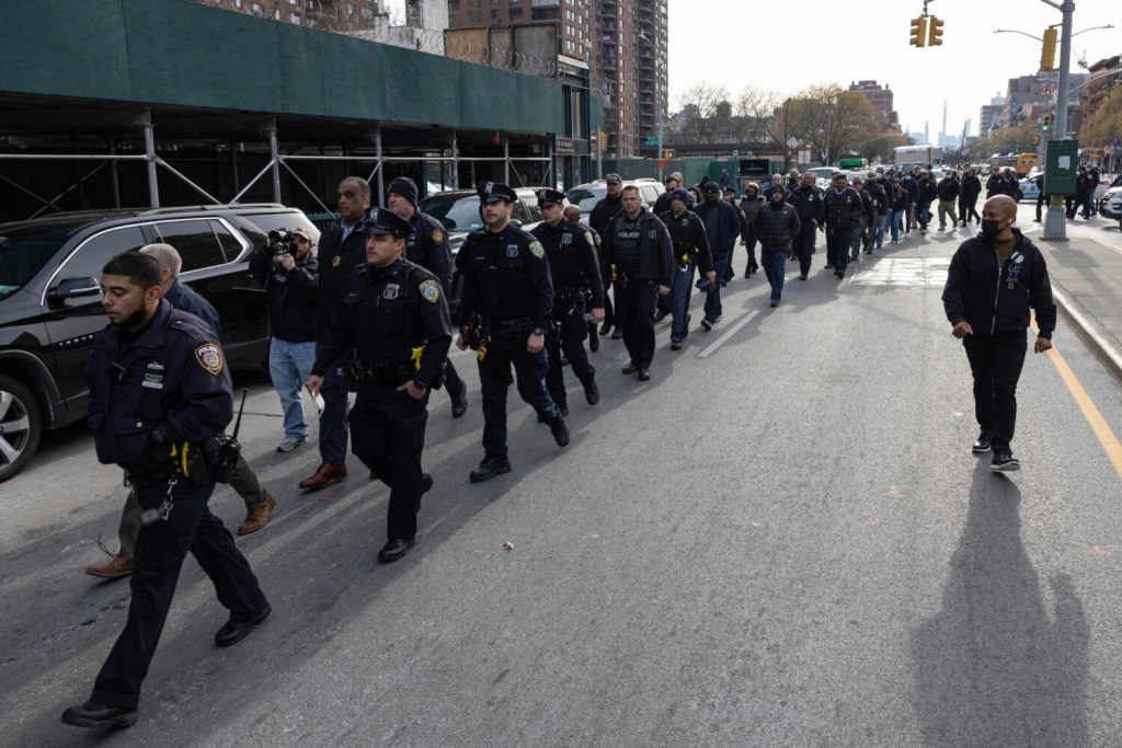 Police officers from New York and Westchester march from the NYPD 32nd precinct to Harlem Hospital on Sunday near the scene of a shooting in the Harlem neighborhood of New York.