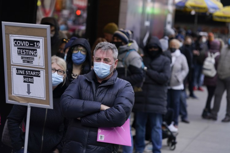 People wait in line at a COVID-19 testing site Monday in Times Square, New York.