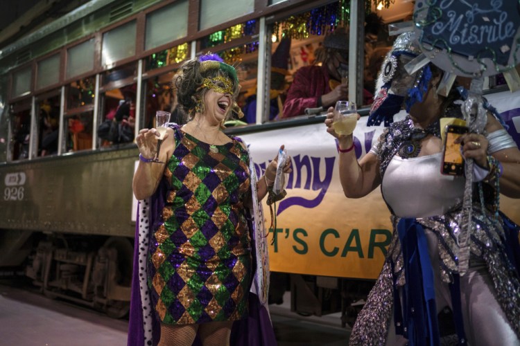The Phunny Phorty Phellows Queen Julie Holman, left, dances before hopping onto the streetcar Thursday to take the historic Twelfth Night ride to announce that Carnival has begun in New Orleans. The Phellows are a Mardi Gras organization that first took to the streets in 1878 and ceased parading in 1898. The group was revived in 1981. They were known for their satirical parades, and today's krewe members' costumes often reflect current events. 

