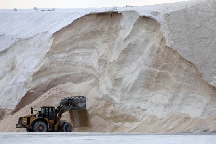 A front-end loader works in front of a pile of road salt Friday in Chelsea, Mass. Residents and officials in the Northeast and mid-Atlantic regions braced for a powerful winter storm expected to produce blizzard conditions.