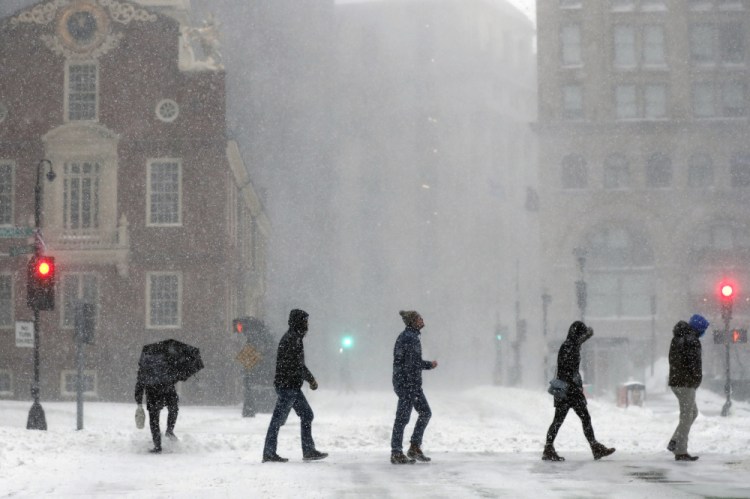 People cross Congress Street on Saturday in Boston. Forecasters watched closely for new snowfall records, especially in Boston, where the heaviest snow was expected late Saturday. (AP Photo/Michael Dwyer)
