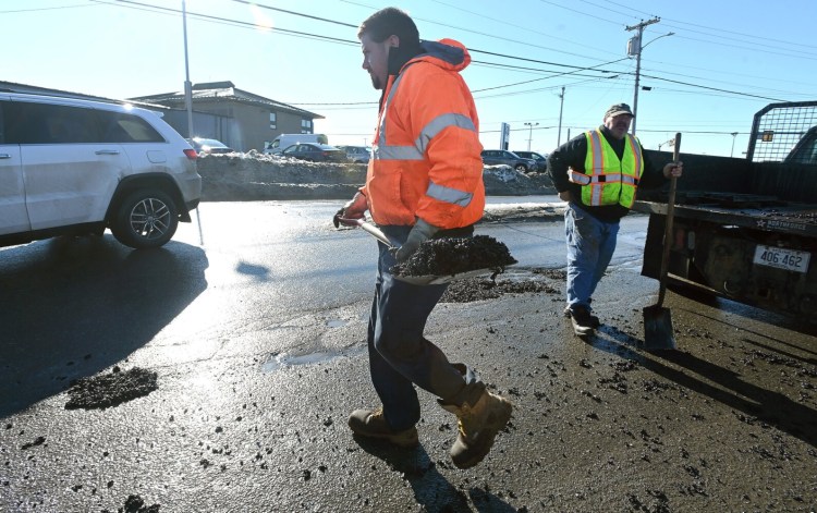 3353# 01potholes WATERVILLE, MAINE Bobby Bellows of Waterville Public Works carries a scoop of cold patch while filing potholes on Armory Road in Waterville, Maine Wednesday February 9, 2022.(Rich Abrahamson/Morning Sentinel)