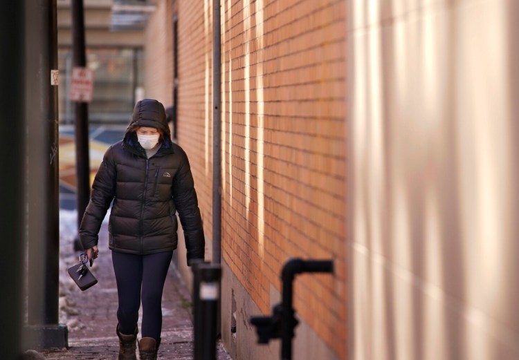 PORTLAND, ME – JANUARY 10: A woman wearing a mask walks along Brown Streetf in Portland on Monday, January 10, 2021. (Staff photo by Gregory Rec/Staff Photographer)
