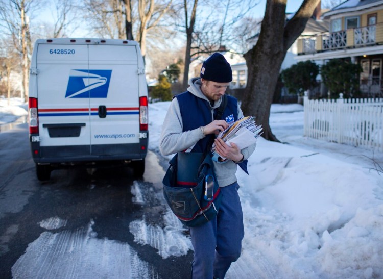 Alexander Gage delivers mail in Portland on Wednesday. Representatives of southern Maine postal workers said they support a federal bill to reform the post office's finances, but they don't think it will speed up the mail.