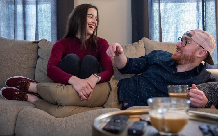 Kelsey Biliouris cuddles Sunday with fiance Daniel Taylor at their home in Wilton as they rewatch their appearance last week on "The Ellen DeGeneres Show," during which they played a game and got engaged.