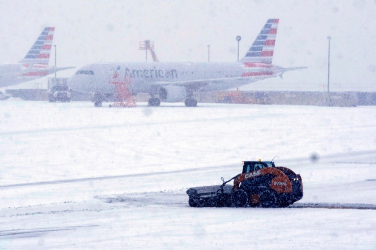 Snow and ice are cleared from the tarmac at Dallas Fort Worth International Airport in Grapevine, Texas, on Thursday. 