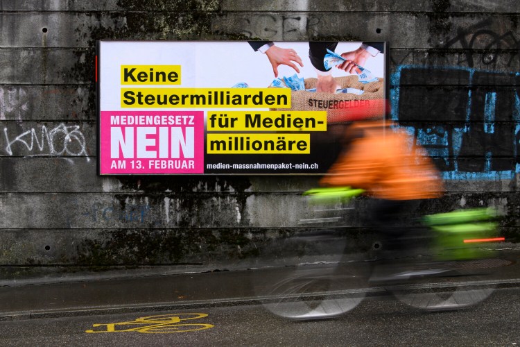 A poster reading 'No tax billions for media millionaires. Media Law No' displayed on a wall in Bern, Switzerland. Swiss voters on Sunday rejected a government plan to inject more than 150 million francs (about $163 million) into broadcast and print media every year. 