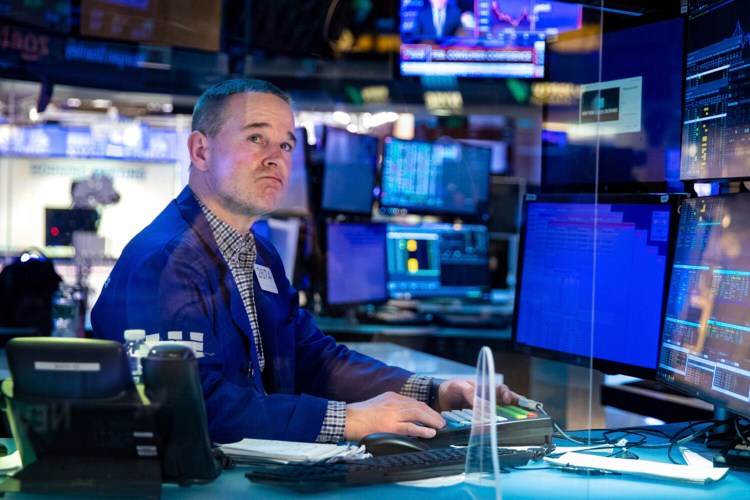 Stephen Naughton works at his post on the New York Stock Exchange trading floor on Tuesday. Oil prices  remain elevated as investors prepare for a fallout in global energy markets.