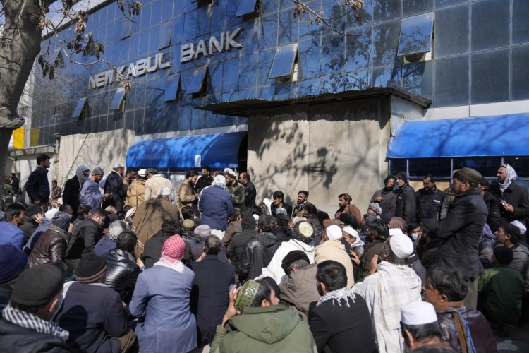 Afghans wait to enter a bank in Kabul, Afghanistan, on Sunday. Poverty in in the country is growing. At banks, residents wait in line for hours, sometimes days, to withdraw a limit of $200 a week.