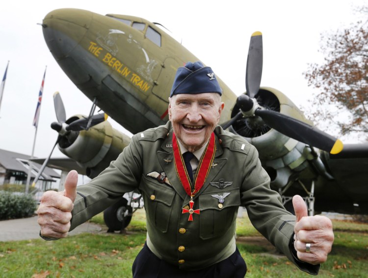 "Candy Bomber" pilot Gail Halvorsen gives thumbs up in front of an old U.S. military aircraft in Frankfurt, Germany in 2016. The man known as the "Candy Bomber" for his airdrops of sweets during the Berlin Airlift when World War II ended nearly 75 years ago has died. (AP Photo/Michael Probst)