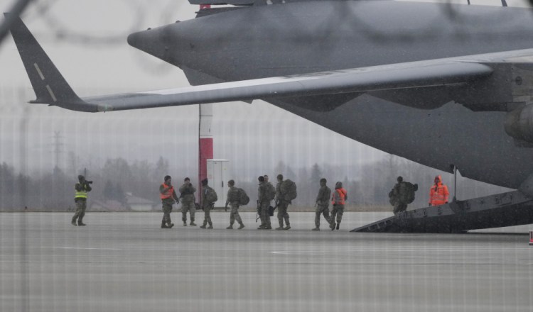 U.S. Army troops of the 82nd Airborne Division unloading vehicles from a transport plane after arriving from Fort Bragg, at the Rzeszow-Jasionka airport in southeastern Poland, Sunday. Additional U.S. troops are arriving in Poland after President Biden ordered the deployment of 1,700 soldiers here amid fears of a Russian invasion of Ukraine.