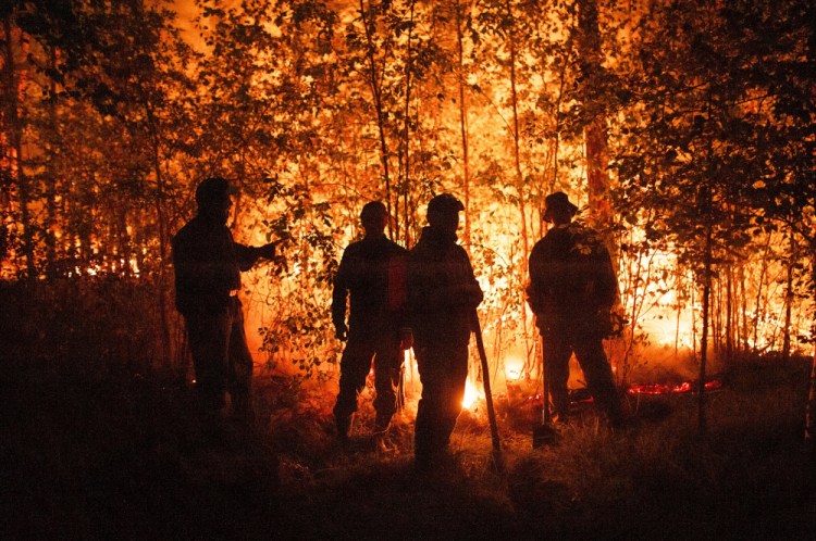 Firefighters work near Kyuyorelyakh, west of Yakutsk, Russia, on Aug. 5.

