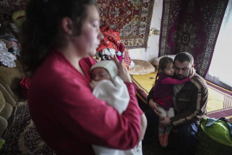 Oleksandr Manha comforts his 4 year-old daughter Sofia as his wife Anastasia Manha, 23, lulls her 2 month-old son Mykyta, where she lives with her family members, after alleged shelling by separatists forces in Novognativka, eastern Ukraine, Sunday.