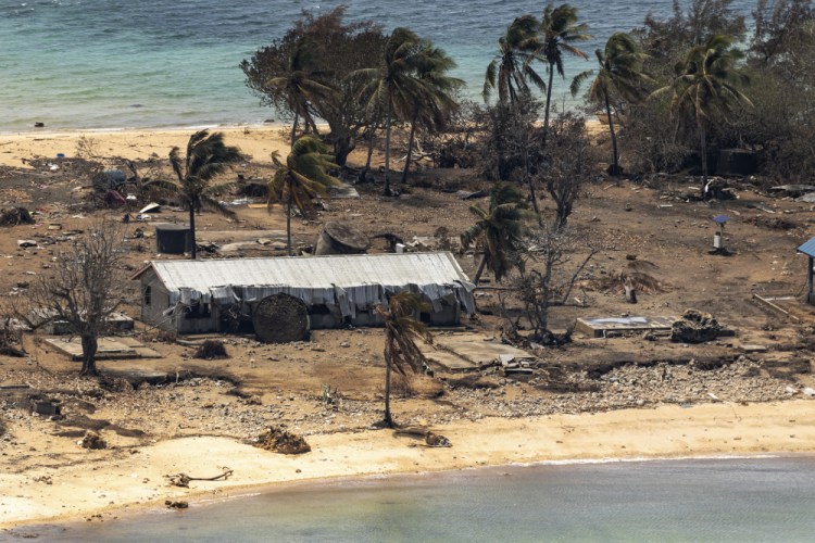 Debris from damaged buildings and trees is strewn around on Atata Island in Tonga on Jan. 28 after the eruption of an underwater volcano and subsequent tsunami. The international aid Tonga accepted after the disaster has caused the country's first COVID-19 outbreak.