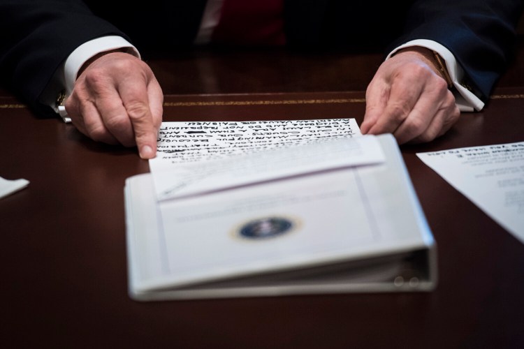 President Donald Trump reads off a paper during a Cabinet meeting in 2018. Trump's ripping of paper was so relentless that his team implemented protocols to try to ensure he was abiding by the law.
