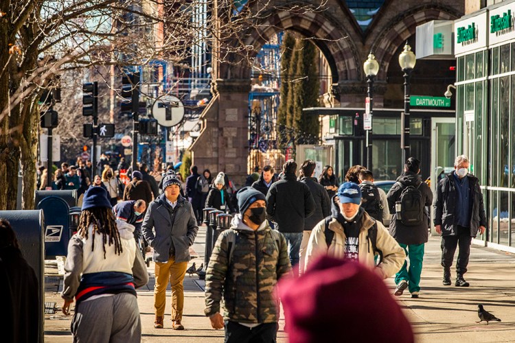 People walk in Boston's Copley Square Wednesday. Massachusetts Gov. Charlie Baker, R, announced that the state's school mask mandate will end Feb. 28. MUST CREDIT: Photo for The Washington Post by Adam Glanzman