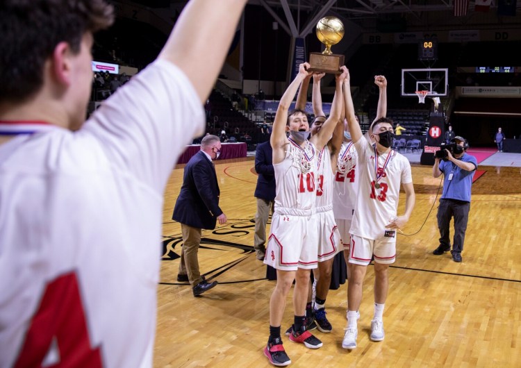 The South Portland boys' basketball team celebrate with their trophy after beating Oxford Hills in the Class AA state championship game on Saturday.