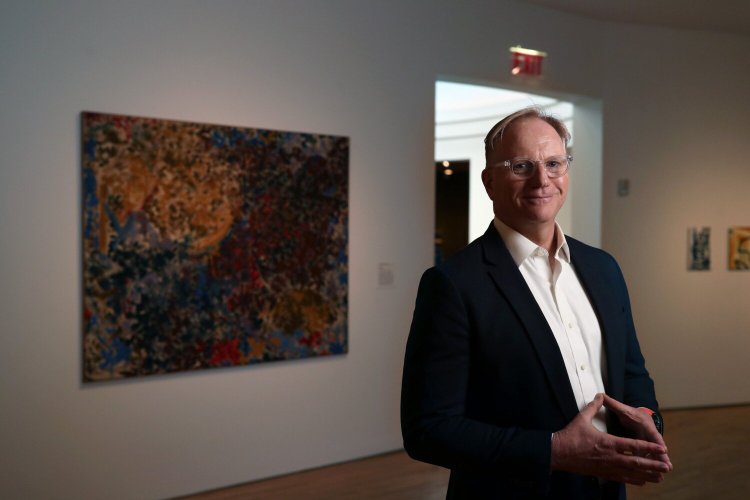 Farnsworth Museum director Christopher Brownawell stands next to "Saha," left, one of four of the museum's Lynne Mapp Drexler paintings. The museum is selling two Drexler paintings, just as she's gaining more fame, to help fund new works for their collection to better diversify. Drexler lived on Monhegan Island until she died in 1999. The Farnsworth sold one of her paintings at auction this month for $1.2 million.