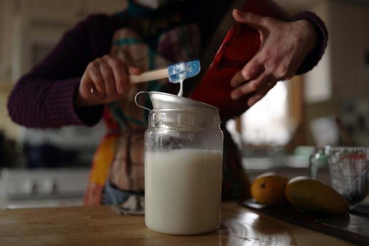 After yogurt starter is whisked into the fresh heated milk, you pour the liquid into a clean jar and leave it to ferment in a warm spot for several hours. Then, et voila, homemade yogurt! (But use a bigger spatula than this inappropriately mini-one Food Editor Peggy Grodinsky grabbed.)