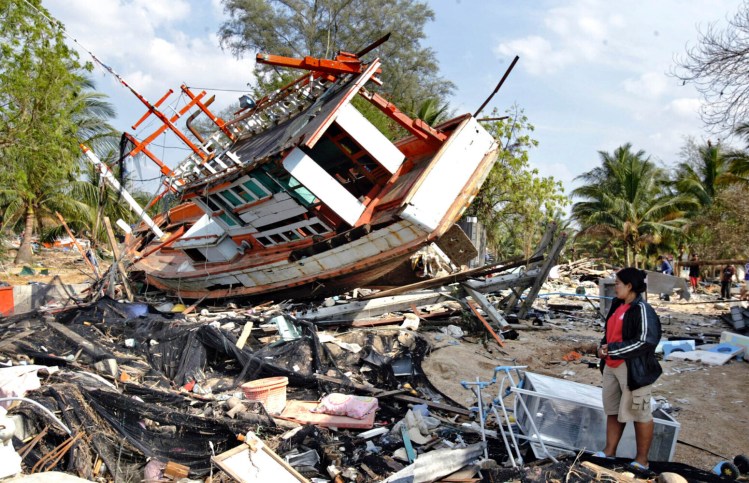 Nataya Pumsi, 36, tries to sort out what to do with the boat that landed on and destroyed her home after her village of Ban Nam Khem in Thailand was hit by a tsunami in 2004.
